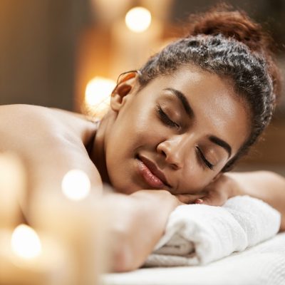 Young beautiful african girl resting relaxing in spa resort with closed eyes.