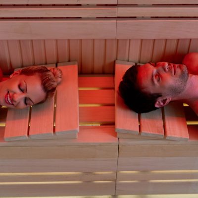 High angle view of a couple relaxing with eyes closed while being in sauna at health spa.